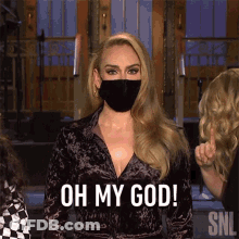 A Woman Wearing A Face Mask Is Standing In Front Of A Group Of People . GIF