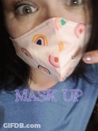 A Woman Wearing A Face Mask With Rainbows On It And The Words Mask Up Below Her GIF