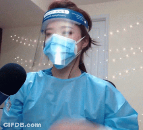 A Woman Wearing A Face Shield And Surgical Mask GIF