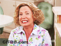 A Woman Wearing A Floral Shirt Is Laughing GIF