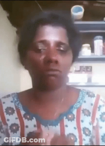 A Woman Wearing A Floral Shirt Is Making A Funny Face With Her Eyes Closed GIF