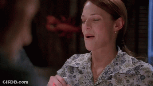 A Woman Wearing A Floral Shirt With Her Mouth Open GIF