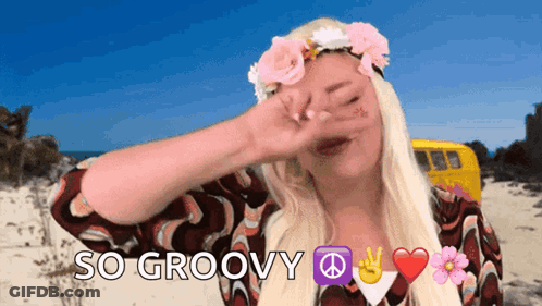 A Woman Wearing A Flower Crown Is Covering Her Face With Her Hand And The Words So Groovy Are Next To Her GIF