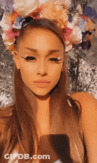 A Woman Wearing A Flower Crown Looks At The Camera GIF