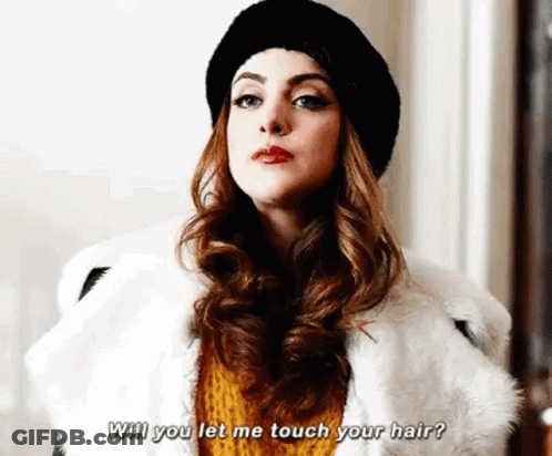 A Woman Wearing A Fur Coat And A Hat Is Talking To Another Woman . GIF