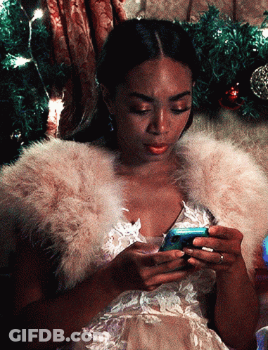 A Woman Wearing A Fur Stole Is Looking At Her Cell Phone GIF