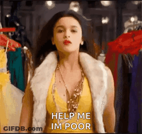 A Woman Wearing A Fur Vest And A Yellow Top Is Standing In Front Of A Clothes Rack And Asking For Help . GIF