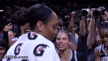 A Woman Wearing A Gatorade Shirt Stands In A Crowd GIF