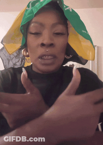 A Woman Wearing A Green And Yellow Bandana That Says Jamaica GIF
