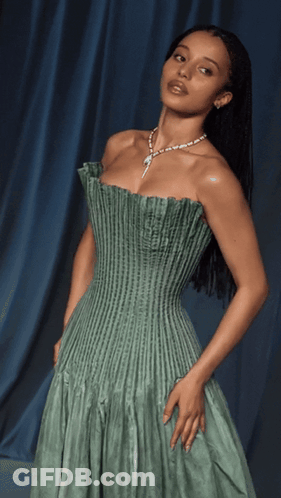 A Woman Wearing A Green Dress And A Necklace GIF
