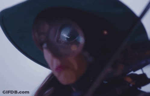 A Woman Wearing A Green Hat And Holding A Violin GIF