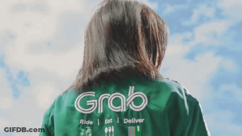 A Woman Wearing A Green Jacket That Says Grab On The Back GIF