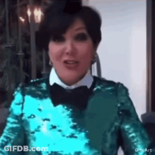 A Woman Wearing A Green Sequined Top And A Black Bow Tie Is Making A Funny Face . GIF