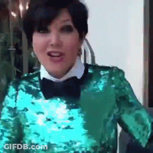 A Woman Wearing A Green Sequined Top And A Bow Tie GIF