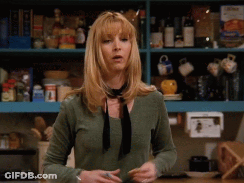 A Woman Wearing A Green Shirt And A Black Tie Is Standing In Front Of A Shelf Full Of Food GIF