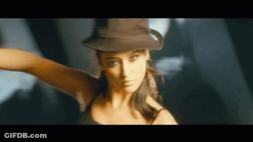 A Woman Wearing A Hat And A Black Tank Top Is Dancing GIF