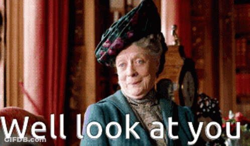 A Woman Wearing A Hat And A Blue Jacket Says Well Look At You GIF