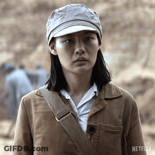 A Woman Wearing A Hat And A Brown Jacket With A Netflix Logo In The Corner GIF