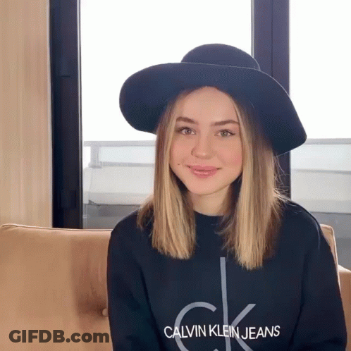 A Woman Wearing A Hat And A Calvin Klein Jeans Shirt GIF