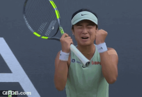 A Woman Wearing A Hat And A Green Tank Top With The Word Asics On It GIF