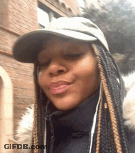 A Woman Wearing A Hat And A Jacket Is Making A Face . GIF