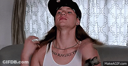 A Woman Wearing A Hat And A Necklace Is Sitting On A Couch And Looking Up . GIF