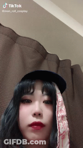 A Woman Wearing A Hat And A Scarf With Tiktok Written On The Bottom GIF