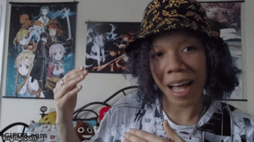 Woman With Hat And Anime Wall Behind GIF