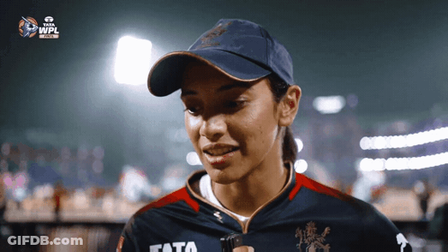 A Woman Wearing A Hat And A Shirt With The Word Tata On It GIF