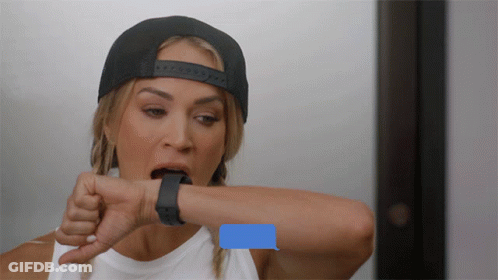 A Woman Wearing A Hat And A Smart Watch Looks At Her Watch With A Message On It GIF