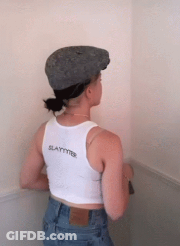A Woman Wearing A Hat And A Tank Top That Says Slayer GIF