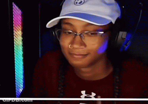 A Woman Wearing A Hat And Glasses Is Smiling And Wearing An Under Armour Shirt GIF