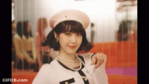 A Woman Wearing A Hat And Pearls Is Giving A Thumbs Up . GIF