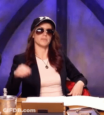 A Woman Wearing A Hat And Sunglasses Is Sitting At A Desk With A Tablet GIF