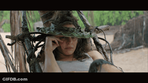 A Woman Wearing A Hat Made Of Leaves And Vines GIF