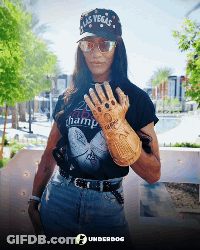A Woman Wearing A Hat That Says Las Vegas Holds Up A Glove GIF