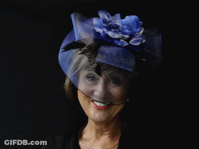 A Woman Wearing A Hat With A Blue Flower On It GIF