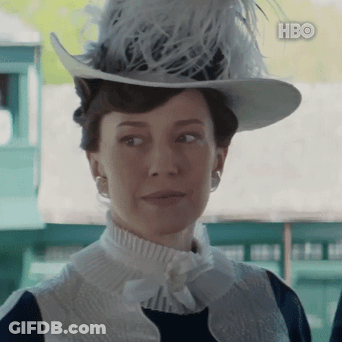 A Woman Wearing A Hat With Feathers And A Hbo Logo GIF