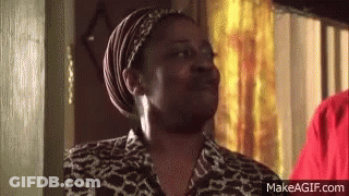 A Woman Wearing A Head Scarf And A Leopard Print Shirt Is Standing In A Room . GIF