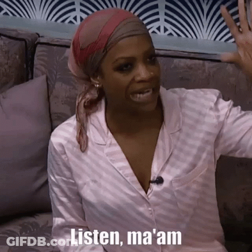 A Woman Wearing A Head Scarf Is Sitting On A Couch And Talking To Someone . GIF
