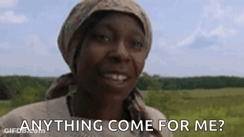 A Woman Wearing A Head Scarf Is Smiling In A Field And Asking Anything Come For Me . GIF