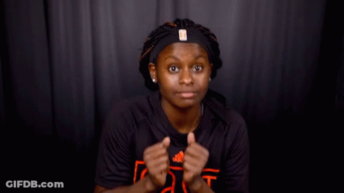A Woman Wearing A Headband And A Black Shirt That Says As GIF