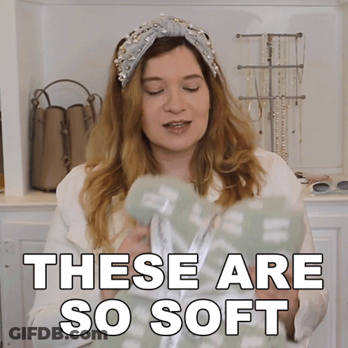 A Woman Wearing A Headband And A White Jacket Says These Are So Soft GIF