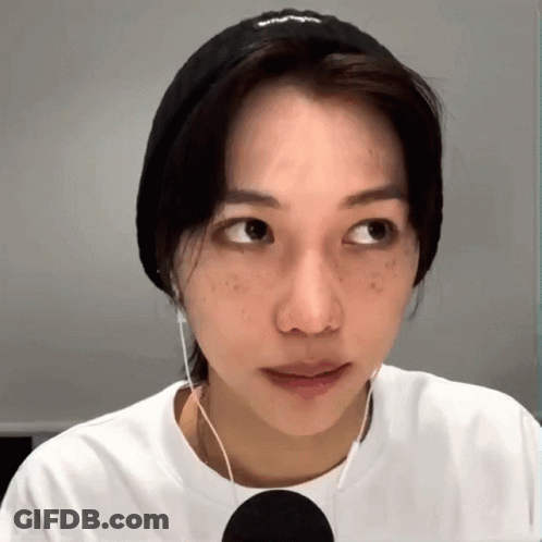 A Woman Wearing A Headband And Earbuds Looks To The Side GIF