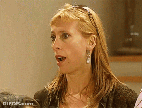 A Woman Wearing A Headband And Earrings Looks Surprised And Shocked GIF