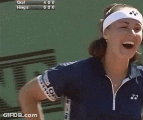A Woman Wearing A Headband Is Smiling In Front Of A Scoreboard That Says Graf Hingis 620 GIF