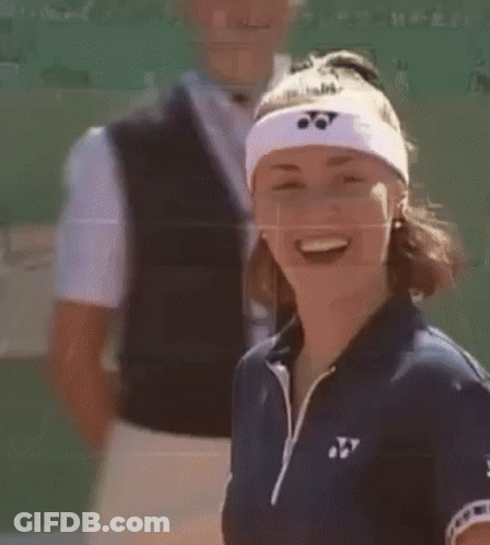 A Woman Wearing A Headband With A Yonex Logo On It Is Smiling . GIF