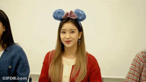 A Woman Wearing A Headband With Mickey Mouse Ears Says " Wait A Minute " GIF
