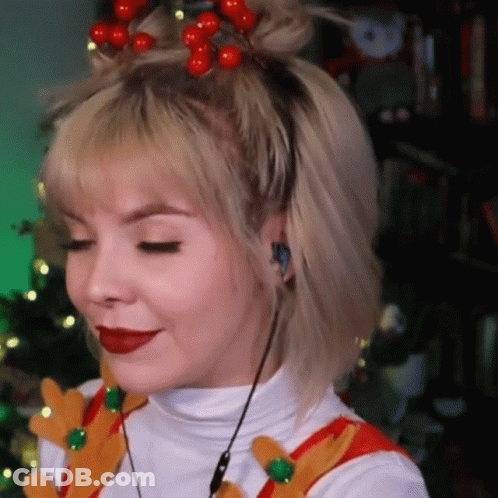 A Woman Wearing A Headband With Red Berries On It Is Smiling . GIF