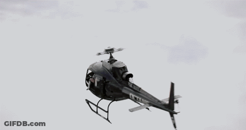 A Woman Wearing A Headset And Gloves Looks Out Of A Helicopter Window GIF